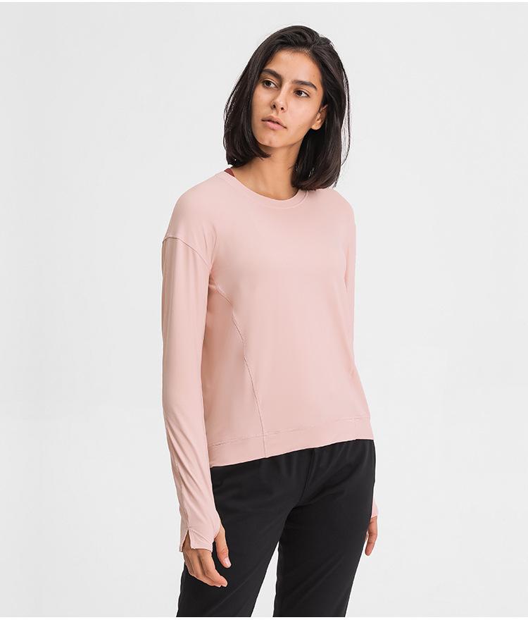 A lightweight long sleeve workout shirt for women, featuring a loose fit and thumb holes, ideal for yoga and fitness activities.