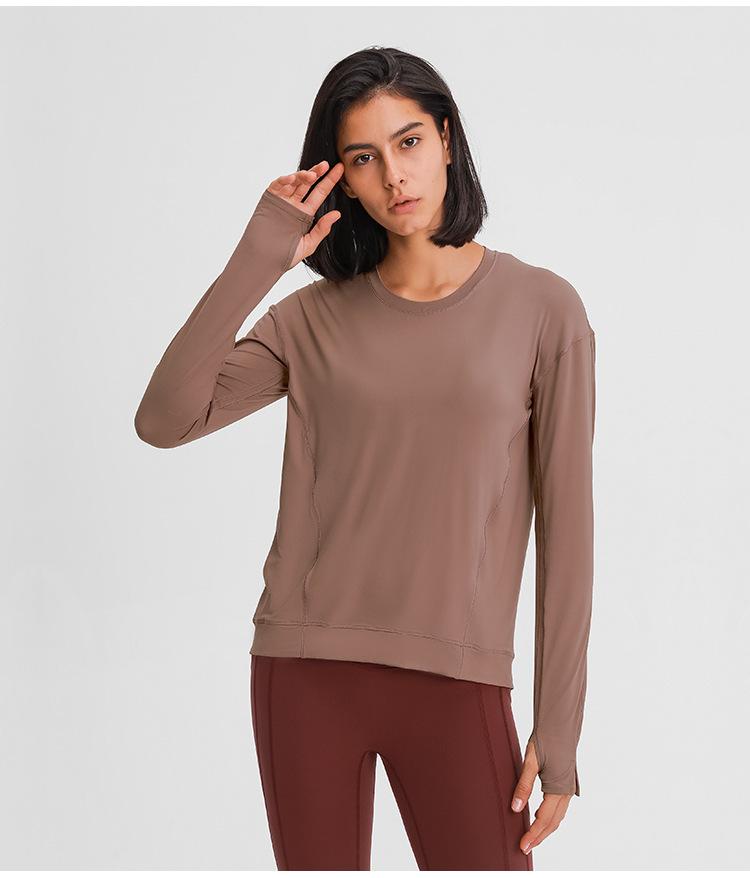 A lightweight long sleeve workout shirt for women, featuring a loose fit and thumb holes, ideal for yoga and fitness activities.