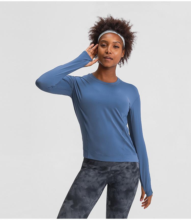 A lightweight long sleeve workout shirt for women, featuring a loose fit and thumb holes, ideal for yoga and fitness activities.