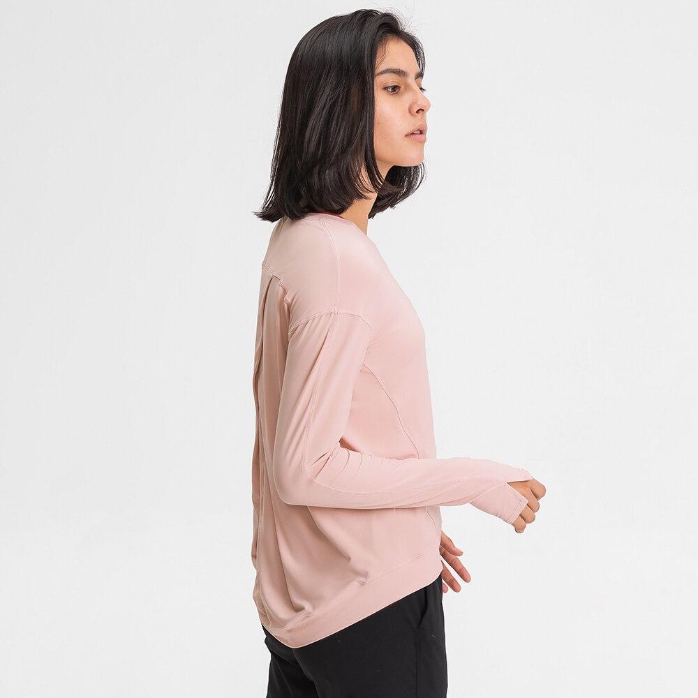 A lightweight long sleeve workout shirt for women, featuring a loose fit and thumb holes, ideal for yoga and fitness activities.