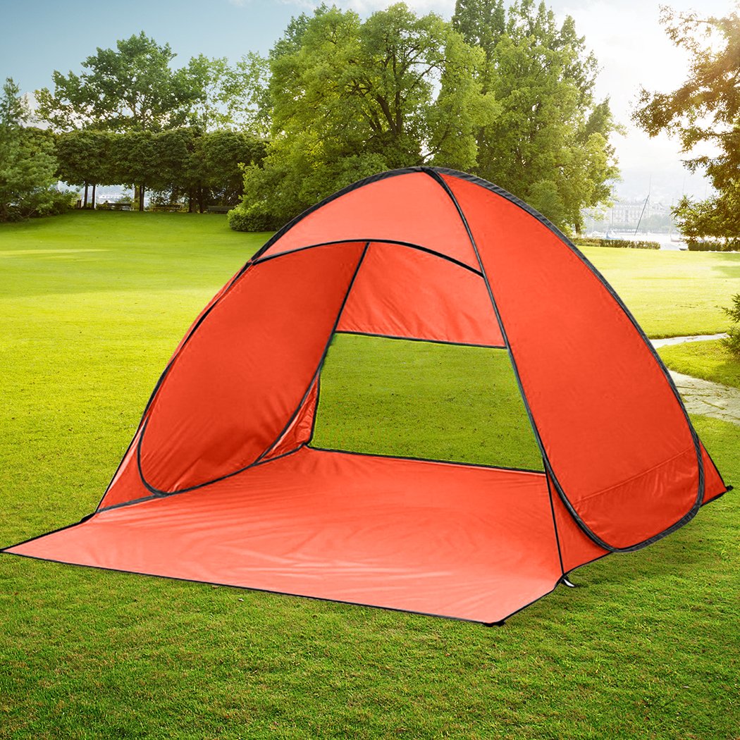 Mountview Pop Up Beach Tent in vibrant orange color, spacious enough for 4 people, set up on a sandy beach with a clear blue sky.