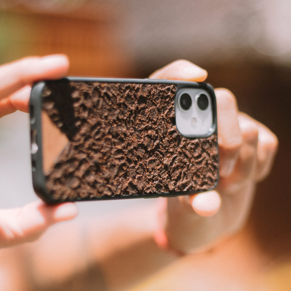 Organic Coffee Phone Case featuring a unique texture and aroma, held by a woman, showcasing its eco-friendly design.