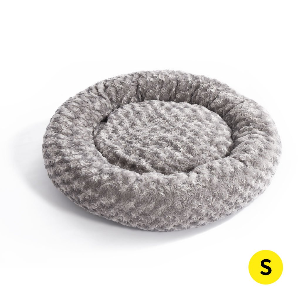 Soft plush pet bed in a calming donut shape, perfect for dogs and cats, featuring a grey color and anti-slip bottom for stability.