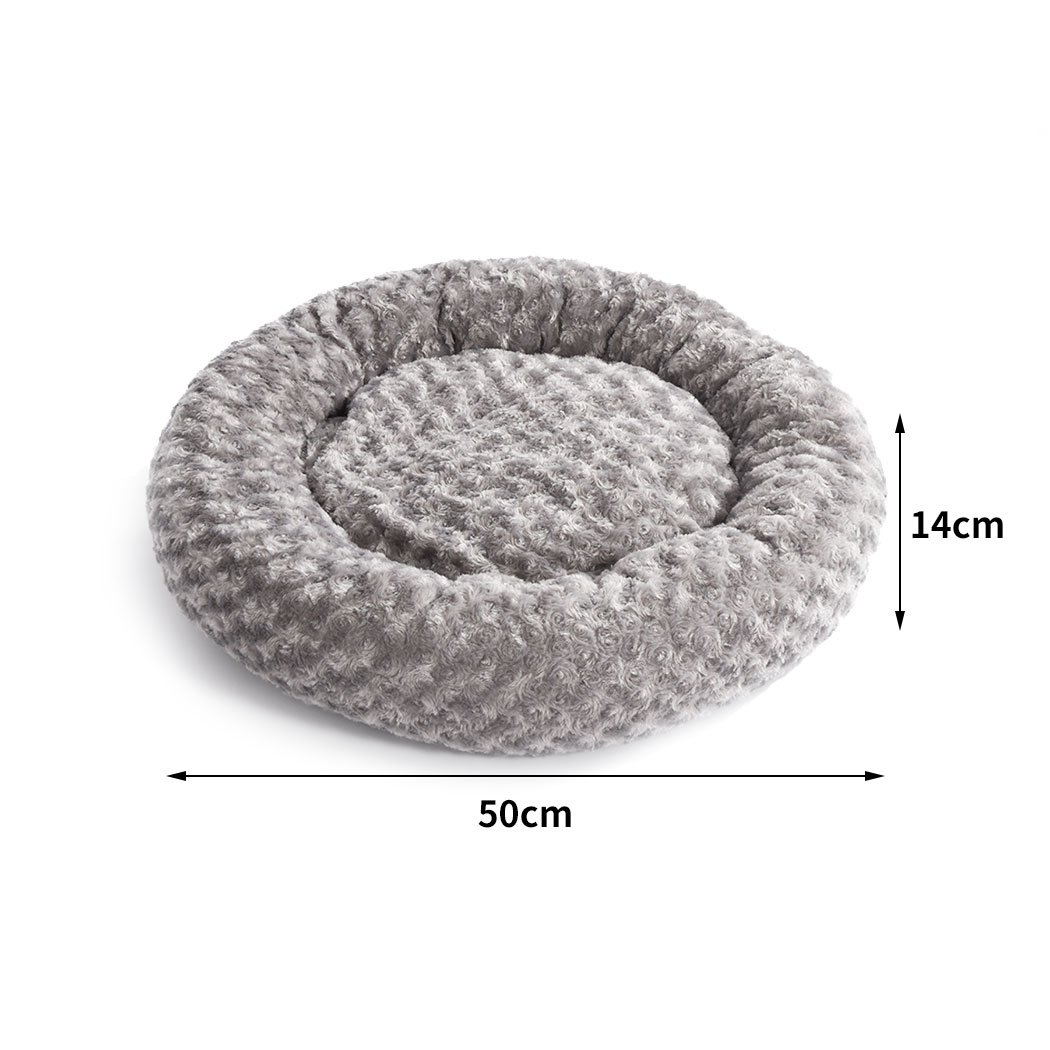 Soft plush pet bed in a calming donut shape, perfect for dogs and cats, featuring a grey color and anti-slip bottom for stability.