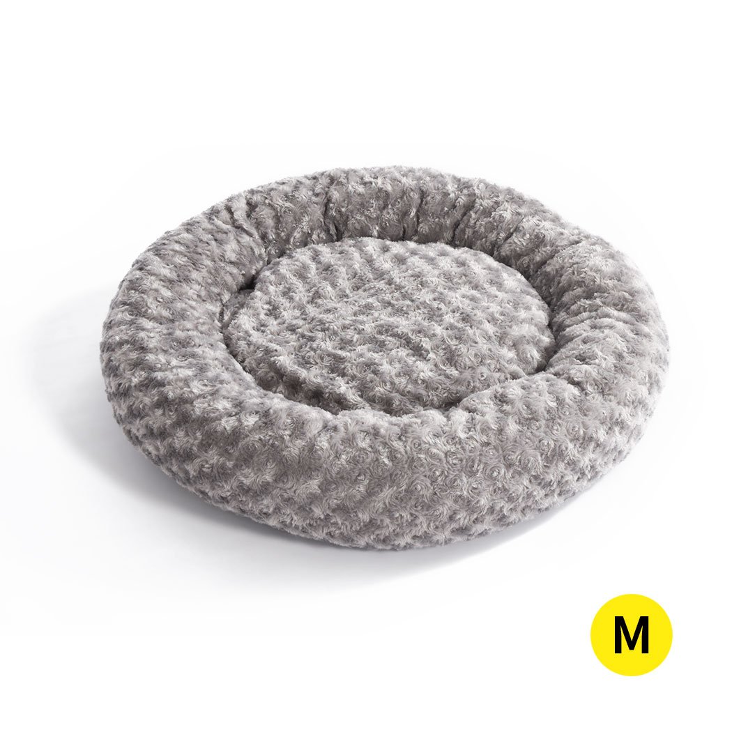 A soft plush donut-shaped pet bed in grey, designed for dogs and cats, featuring a cozy and comfortable interior with an anti-slip bottom.