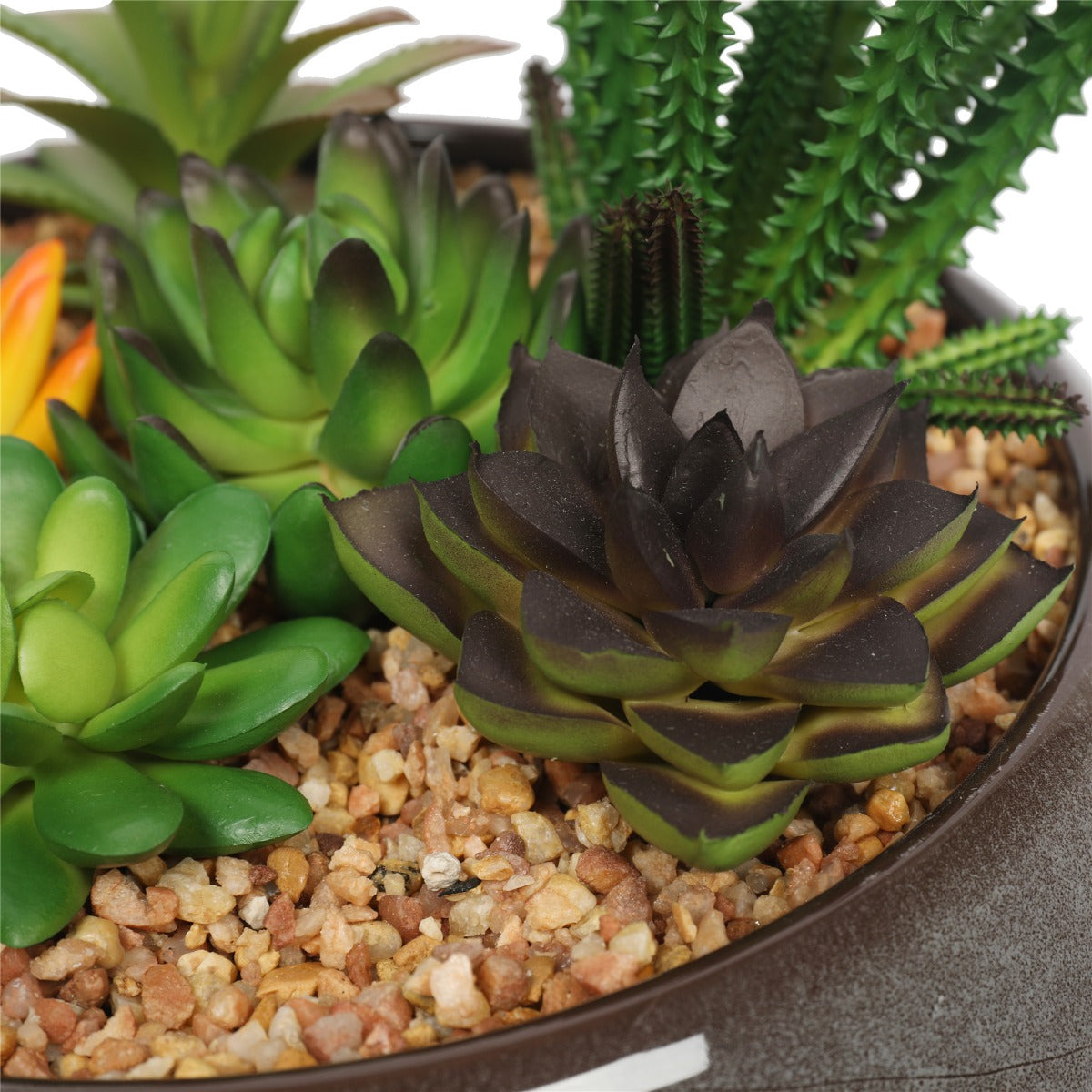 A beautifully arranged potted artificial succulents in a round decorative bowl, featuring lifelike plants and decorative pebbles.