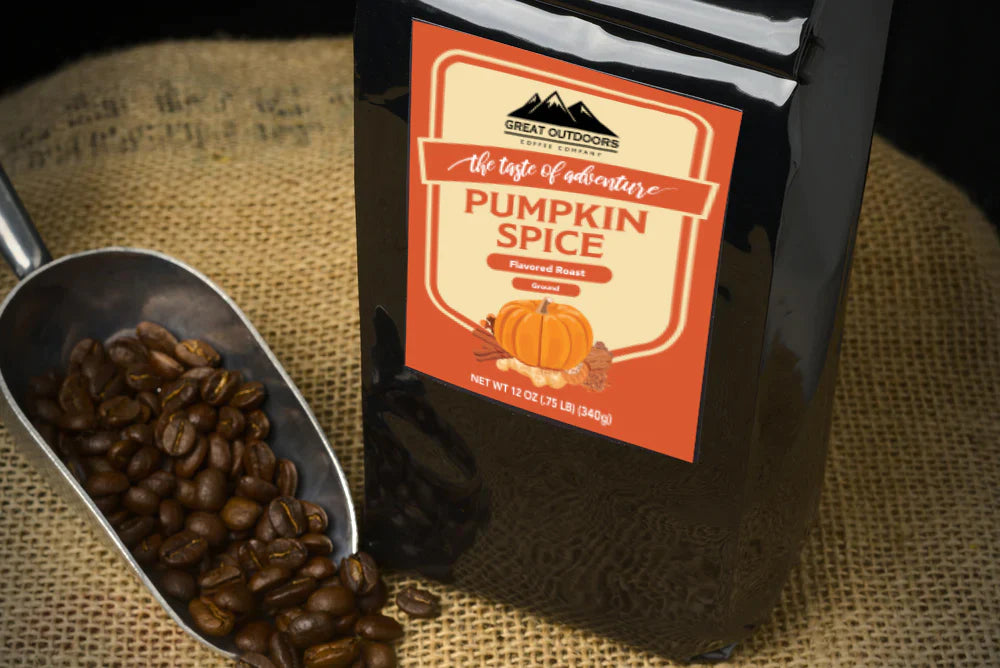 A steaming cup of Pumpkin Spice coffee with autumn leaves in the background, showcasing the warm colors of fall.