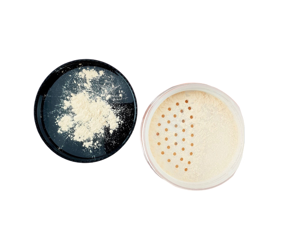 A jar of translucent Setting Powder with a fluffy brush beside it, showcasing its lightweight texture.