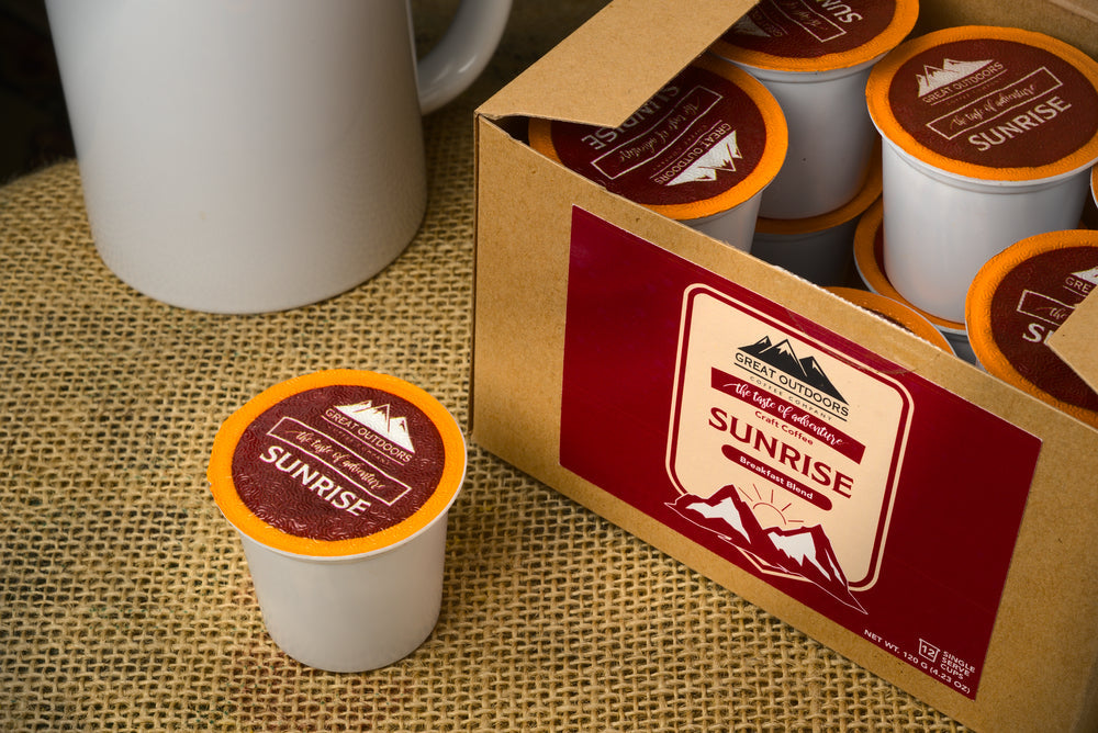 A collection of 48 single serve coffee pods in various flavors, neatly arranged in a box, showcasing the Sunrise, Morning Bite, Double Barrel, and Campfire blends.