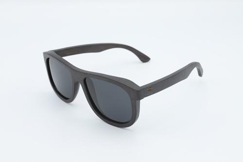 Stylish Skate Sunglasses made from skateboard wood with polarized lenses, displayed in a natural setting.