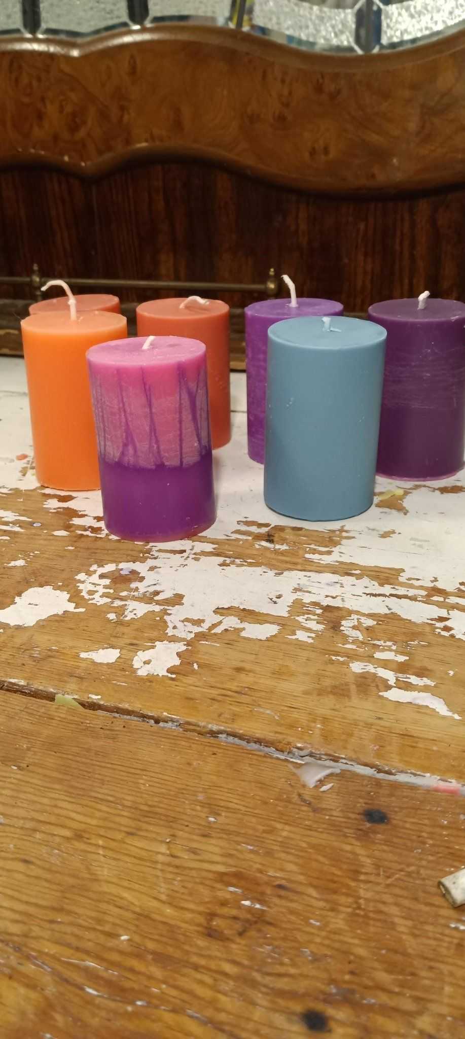 A set of small pillar candles in various colors, showcasing their elegant design and eco-friendly soy wax blend.