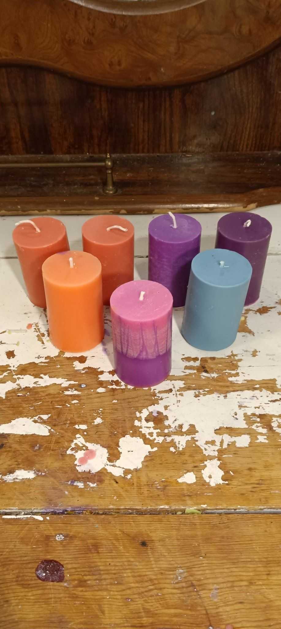 A set of small pillar candles in various colors, showcasing their elegant design and eco-friendly soy wax blend.