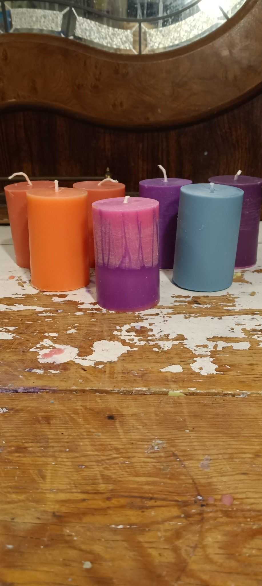 A set of small pillar candles in various colors, showcasing their elegant design and eco-friendly soy wax blend.