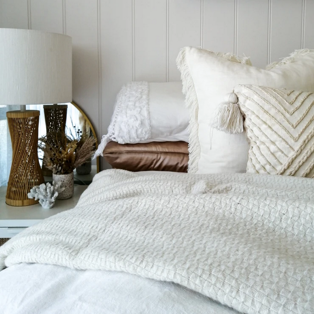 Soho Throw blanket in ivory, showcasing its soft wool blend texture and elegant design, perfect for enhancing living spaces.