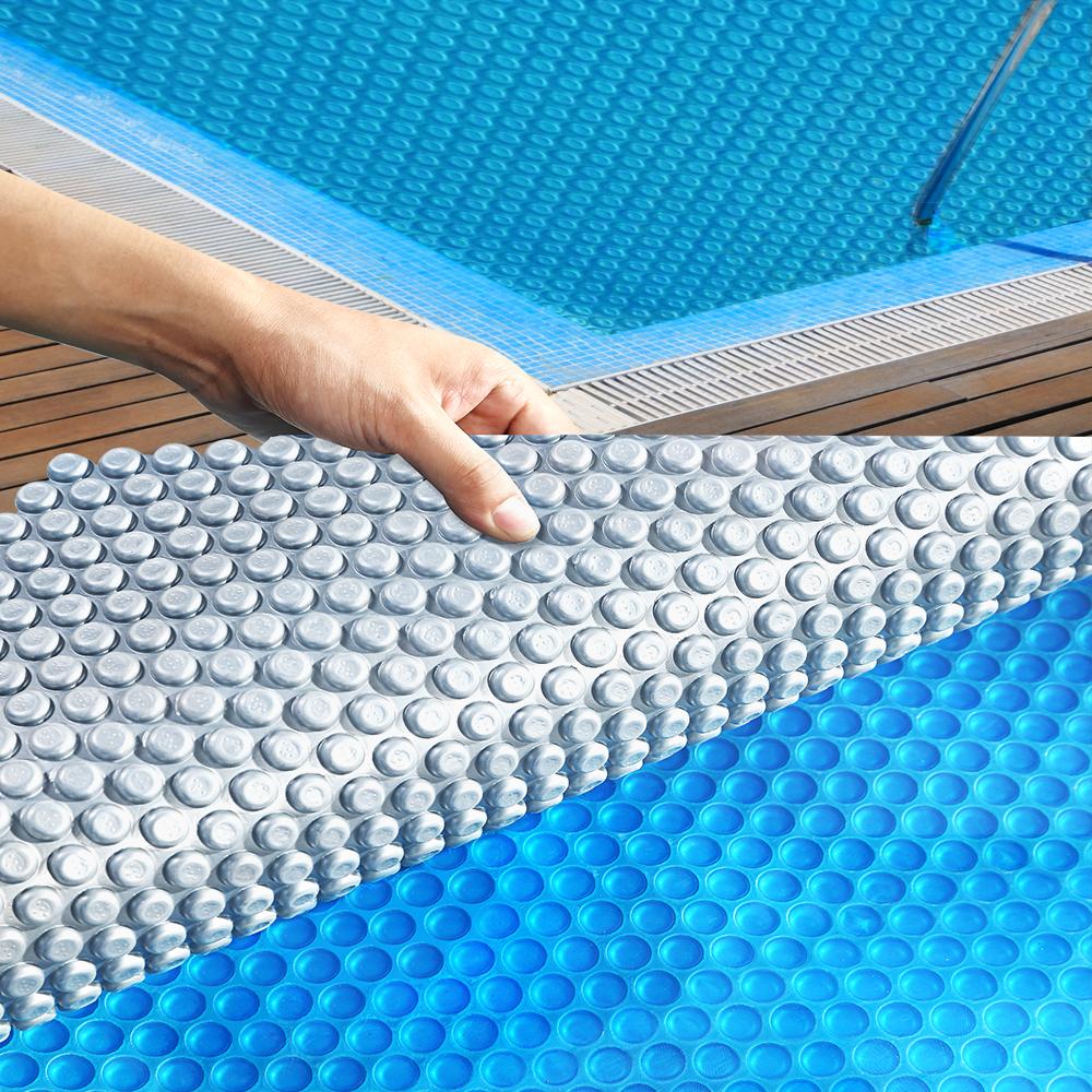 Solar Swimming Pool Cover with blue top and silver bottom, designed for warmth and cleanliness, featuring durable bubbles.