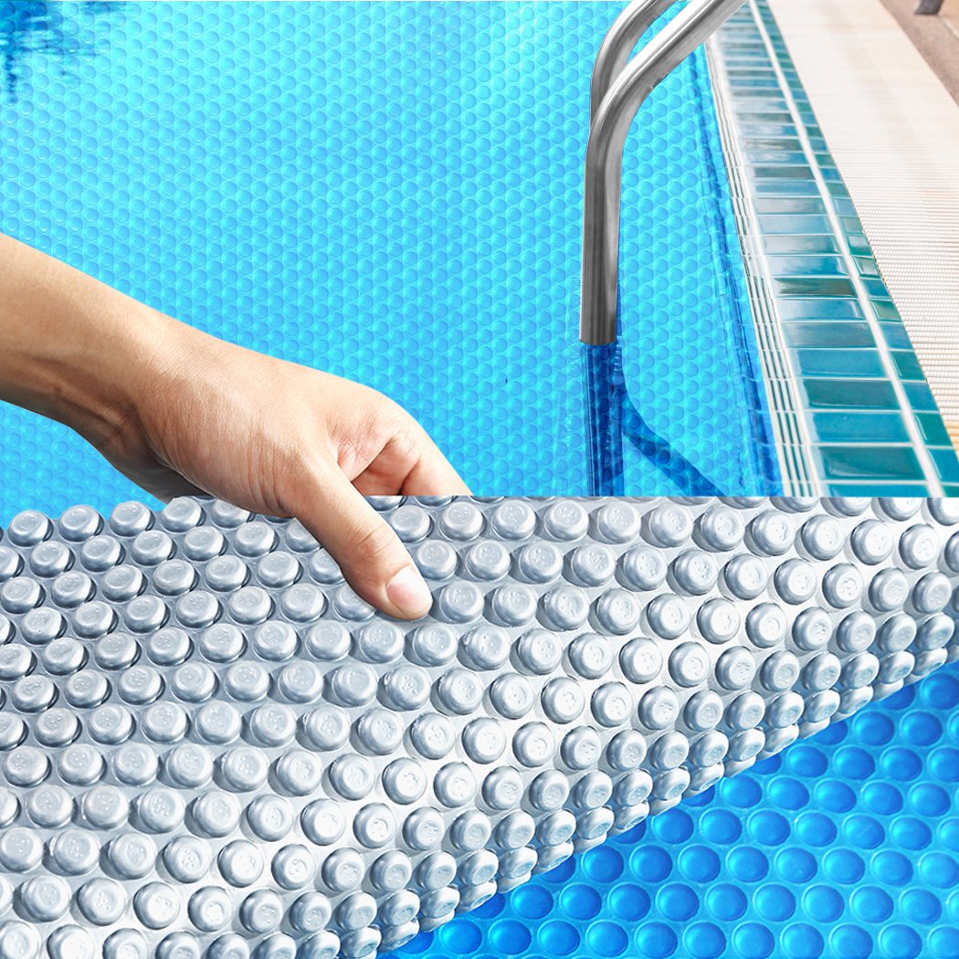 Solar Swimming Pool Cover with blue top and silver bottom, designed to keep pools warm and clean, featuring durable bubbles.