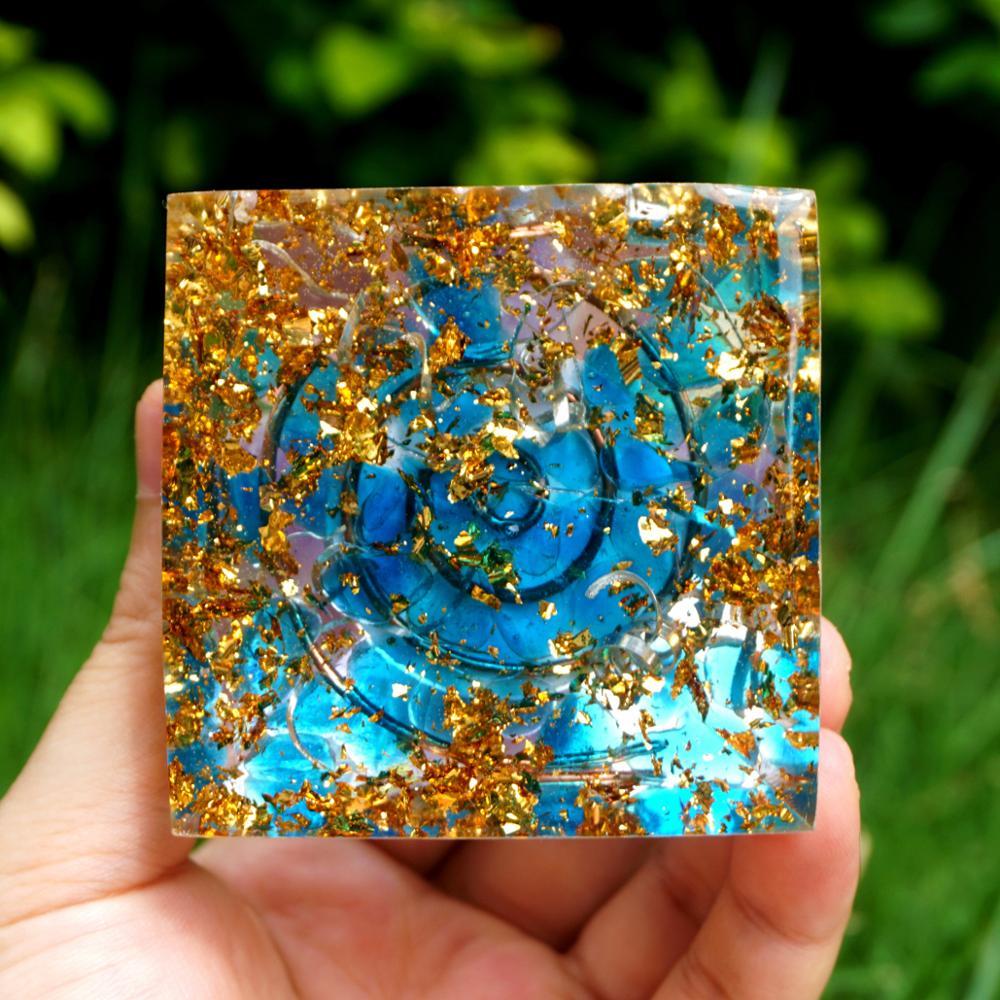 A beautiful Spiritual Energy Orgone Crystal Pyramid featuring an Amethyst crystal at the center, surrounded by a blue cloud and gold foil patterns.