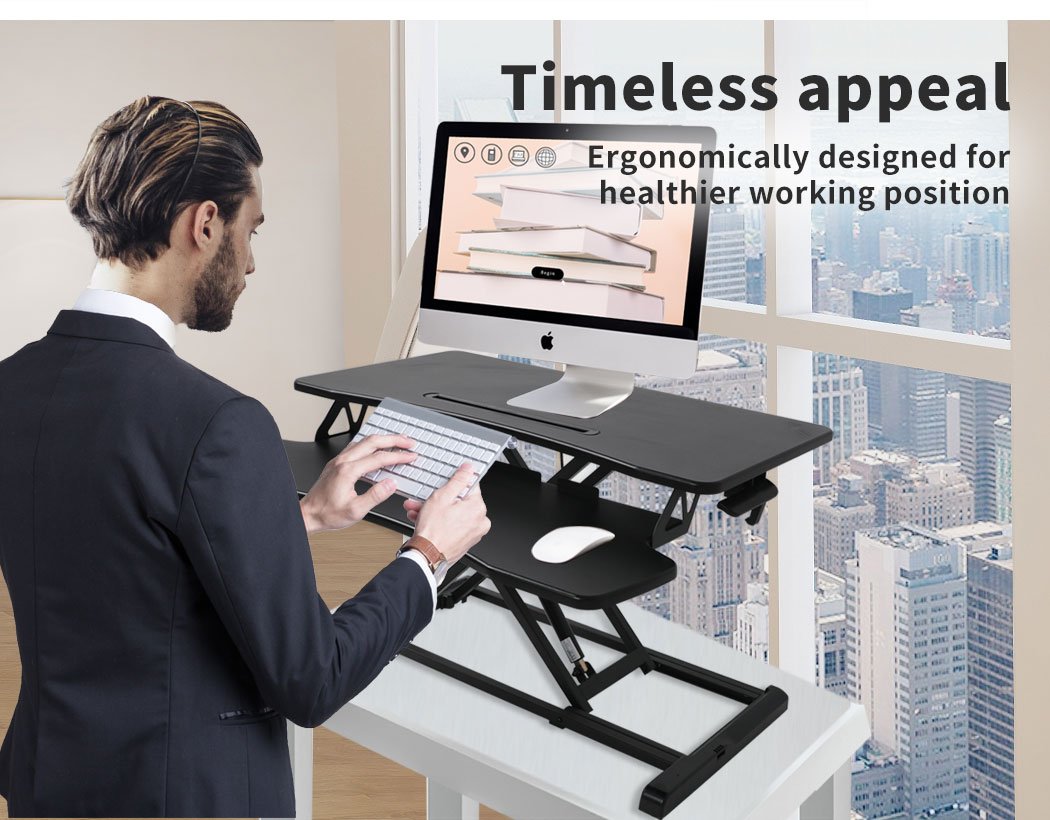 Height adjustable standing desk riser with two-tier design, featuring a sturdy top surface for monitors and a detachable lower deck for keyboard and mouse.