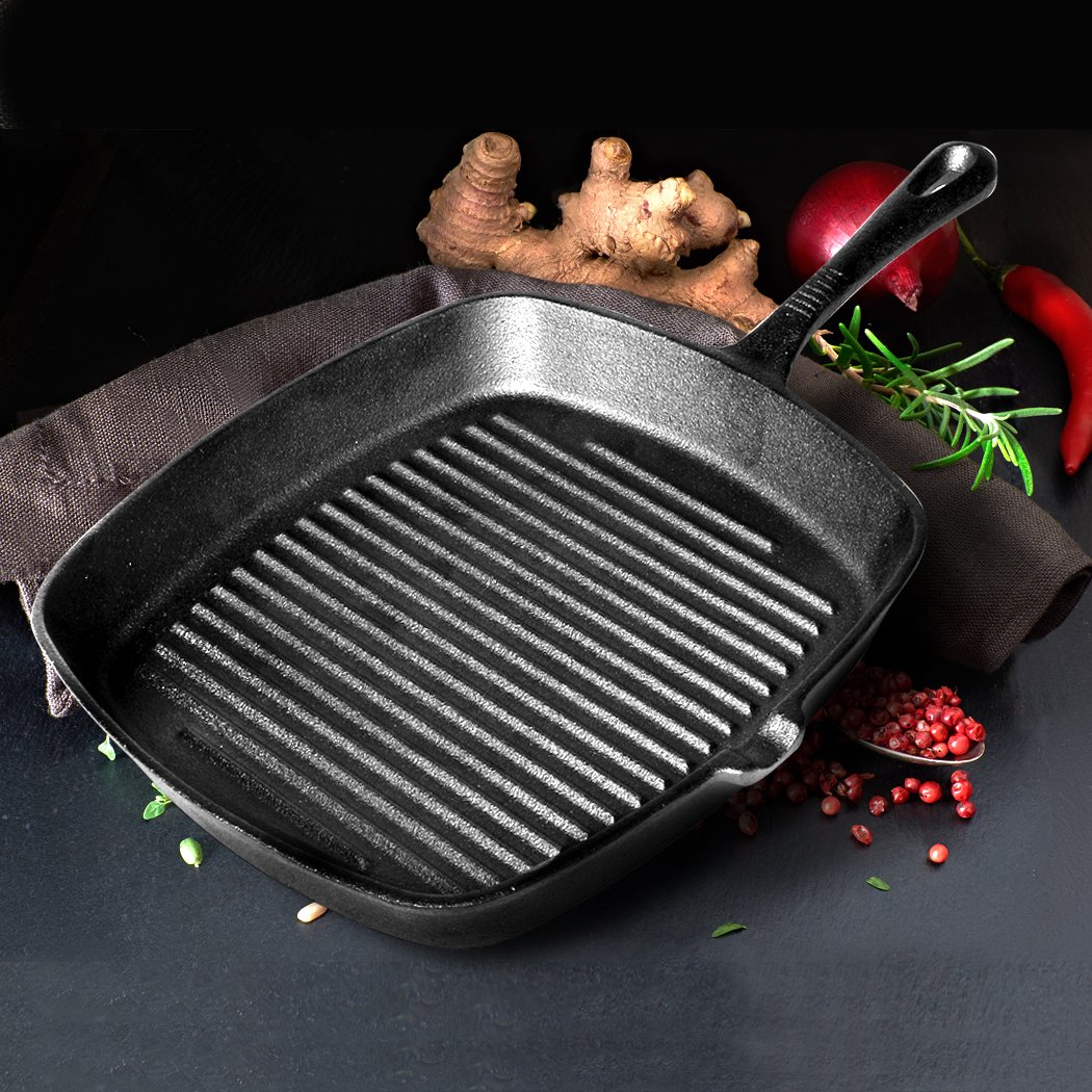 A sleek grey Steak Frying Pan made of FDA cast iron, featuring a non-stick ribbed surface and an anti-slip handle, ideal for gas and induction cookers.