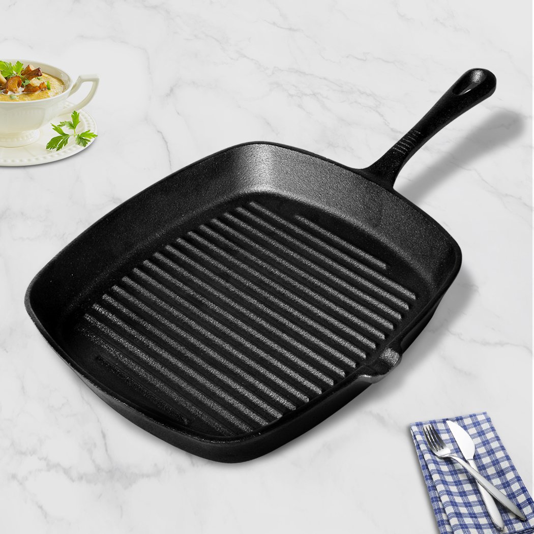 A sleek grey Steak Frying Pan made of FDA cast iron, featuring a non-stick ribbed surface and an anti-slip handle, ideal for gas and induction cookers.