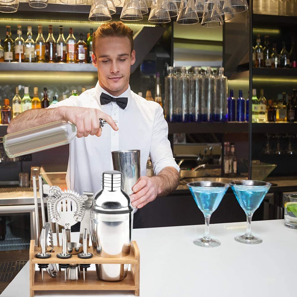 A complete 13-piece Steel Shaker Cocktail Bar Set Kit displayed on a wooden stand, showcasing various bar utensils including a shaker, measuring cup, and straws.