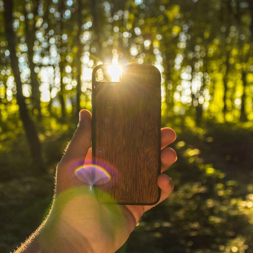 Sucupira wooden phone case held in hand, showcasing its unique grain and finish.