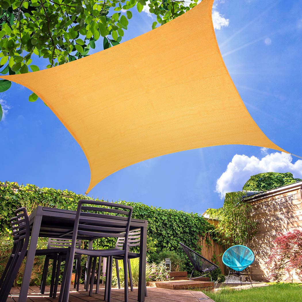 A square Sun Shade Sail in beige color, providing shade in an outdoor setting, showcasing its durable fabric and corner rings for easy installation.