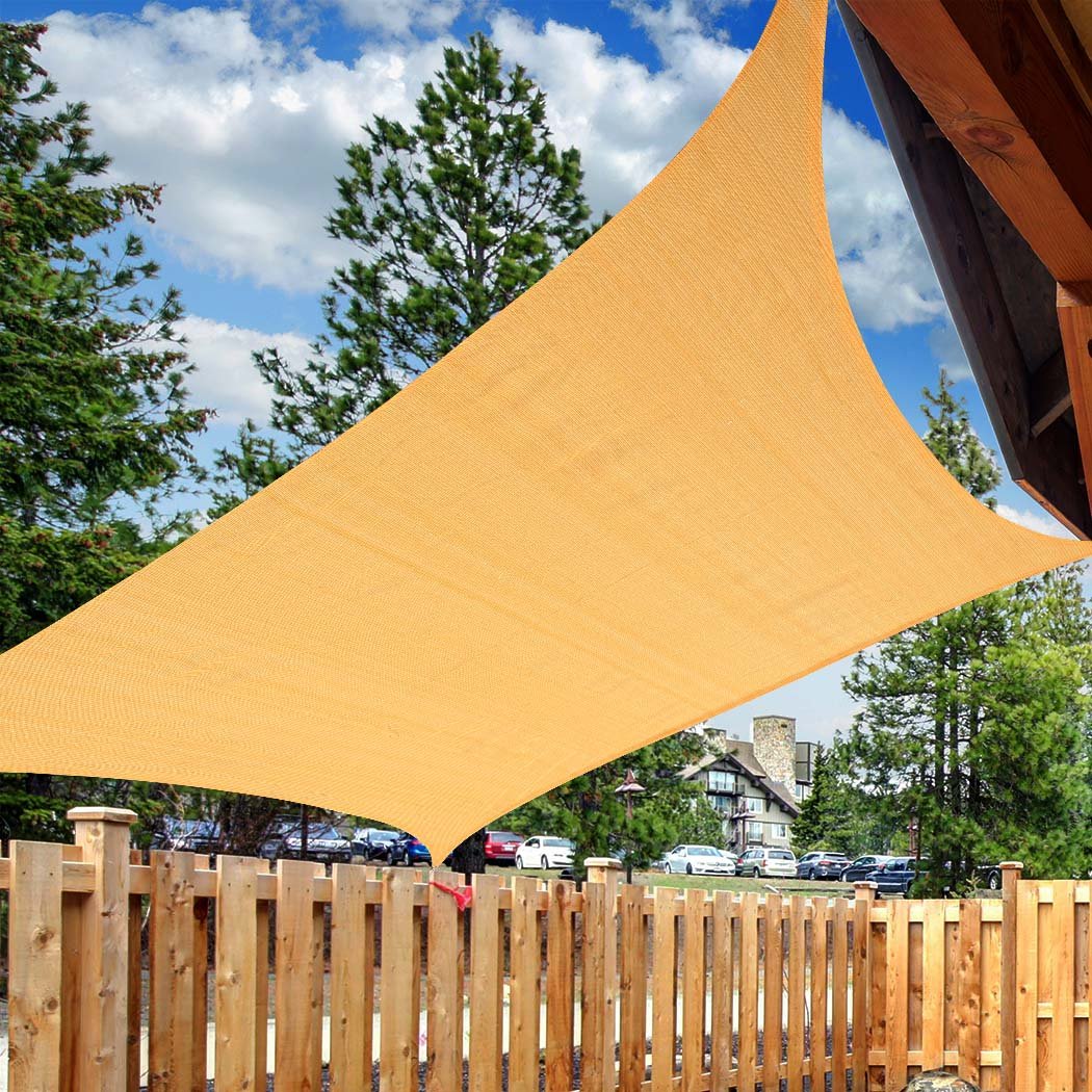 A square Sun Shade Sail in beige color, providing shade in an outdoor setting, showcasing its durable fabric and corner rings for easy installation.