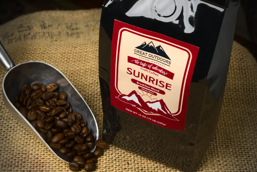 A bag of Sunrise craft coffee blend featuring 100% Arabica beans with a warm sunrise background.