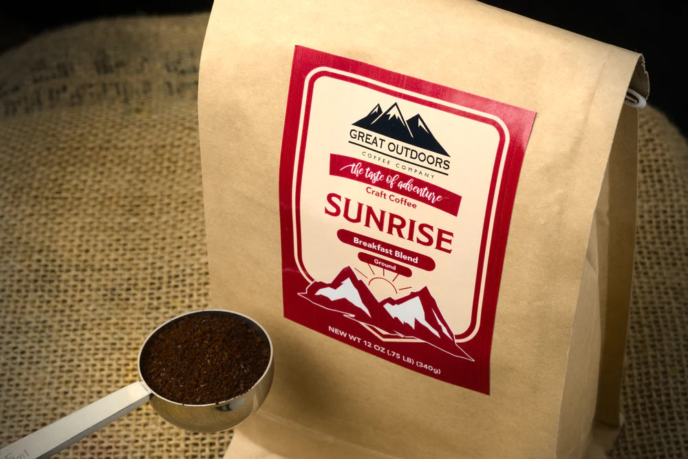 A bag of Sunrise craft coffee blend featuring 100% Arabica beans with a warm sunrise background.