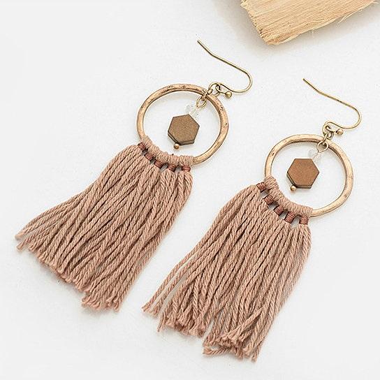 A pair of Tassela Trendy Earrings featuring olive and tan tassels, onyx and crystal accents, and a hammered gold finish.