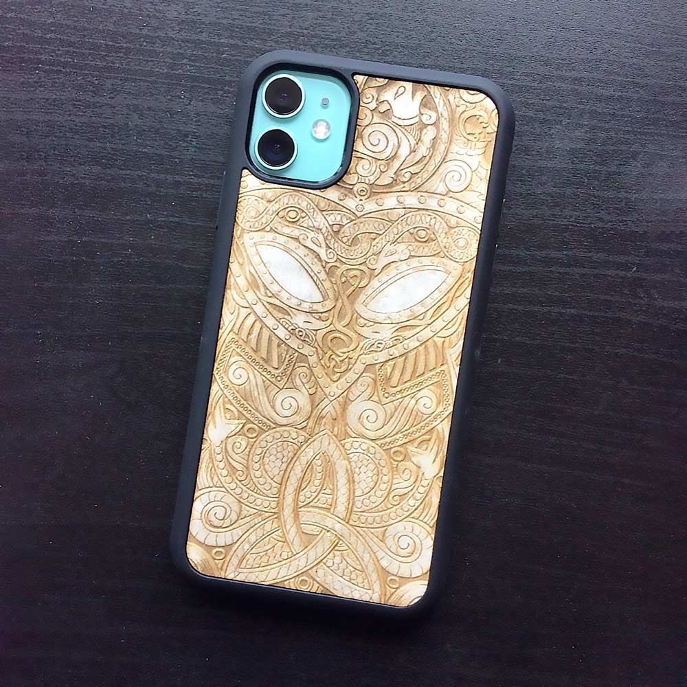 Handcrafted Viking wooden phone case showcasing unique wood grain and Norse symbols, held in a woman's hand.