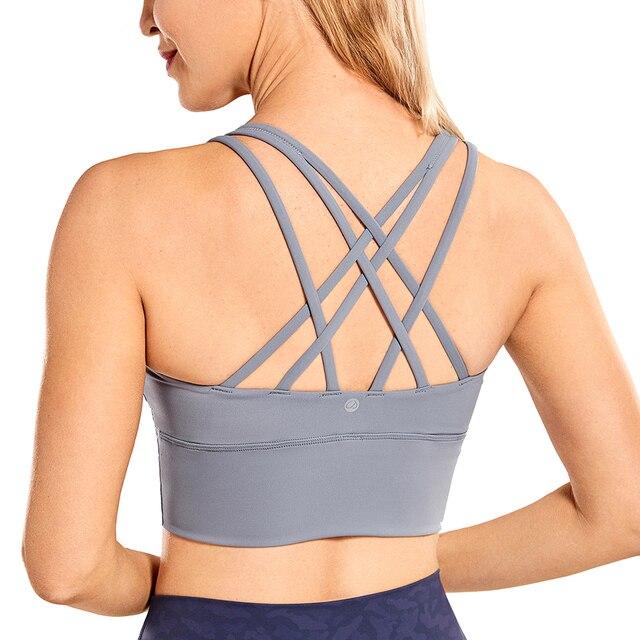 A stylish wirefree padded strappy yoga bra in a longline design, perfect for medium impact sports and yoga, showcasing its breathable fabric and trendy straps.