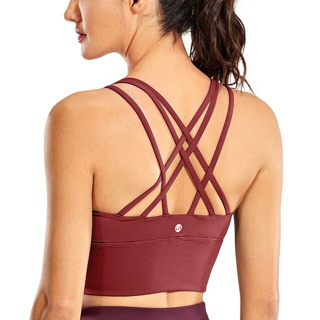 A stylish wirefree padded strappy yoga bra in a longline design, perfect for medium impact sports and yoga, showcasing its breathable fabric and trendy straps.