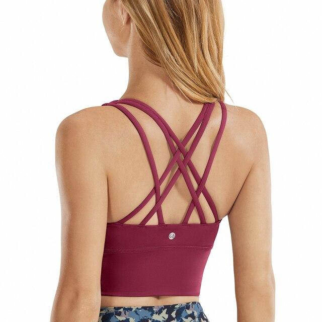 A stylish wirefree padded strappy yoga bra in a longline design, perfect for medium impact sports and yoga, showcasing its breathable fabric and trendy straps.