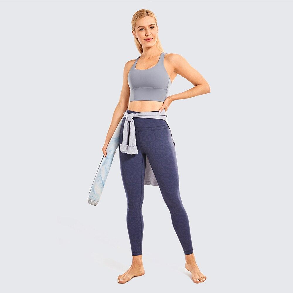 A stylish wirefree padded strappy yoga bra in a longline design, perfect for medium impact sports and yoga, showcasing its breathable fabric and trendy straps.