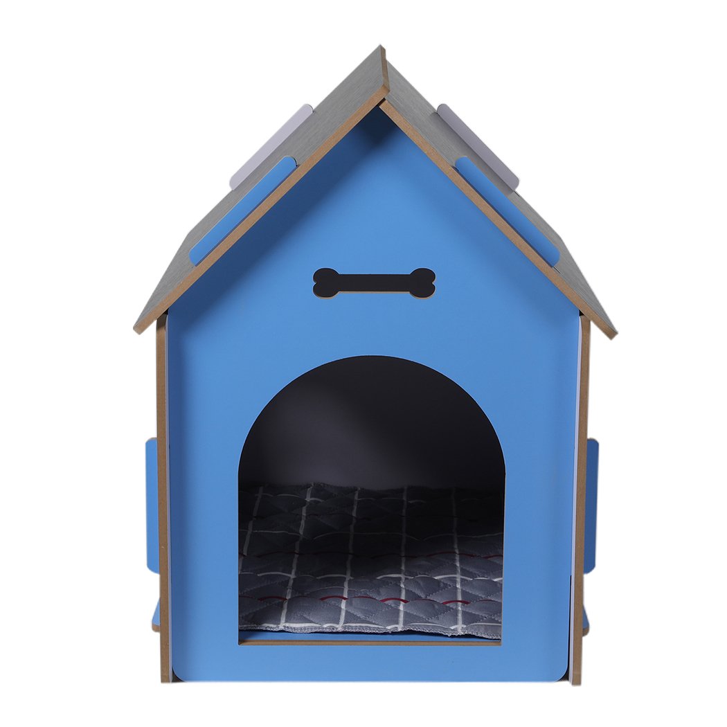 A large blue wooden dog house with an arch door, designed for indoor use, featuring ventilation windows and a cozy pet bed inside.