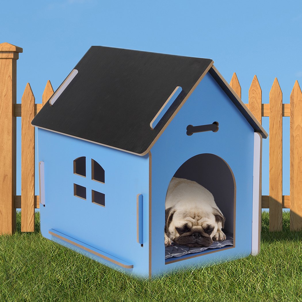 A large blue wooden dog house with an arch door, designed for indoor use, featuring ventilation windows and a cozy pet bed inside.