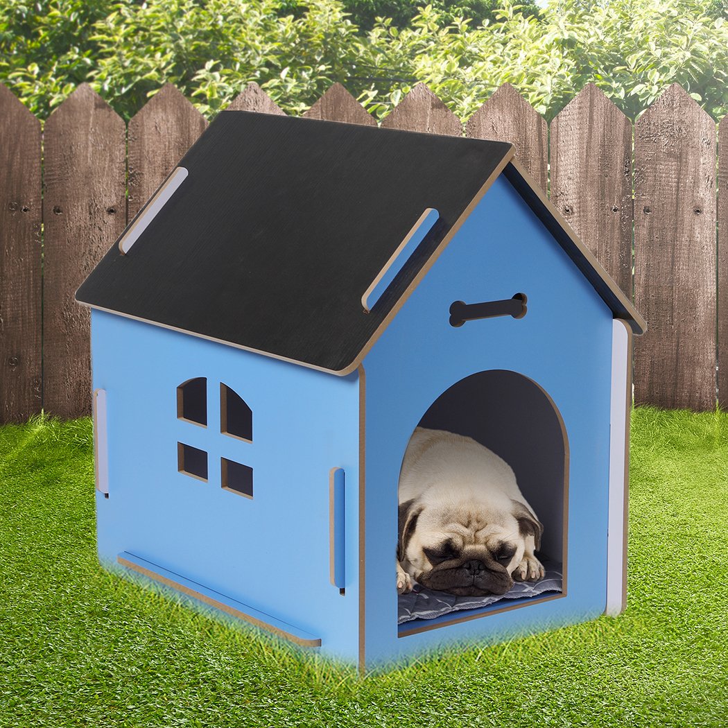 A large blue wooden dog house with an arch door, designed for indoor use, featuring ventilation windows and a cozy pet bed inside.