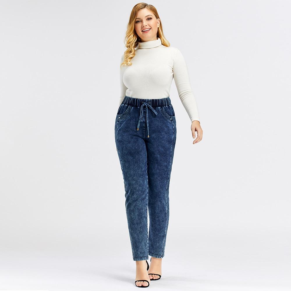 A pair of Women's Plus Size Casual Jeans featuring a mid-rise waist, full-length straight cut, and decorative sashes with lace-up details.