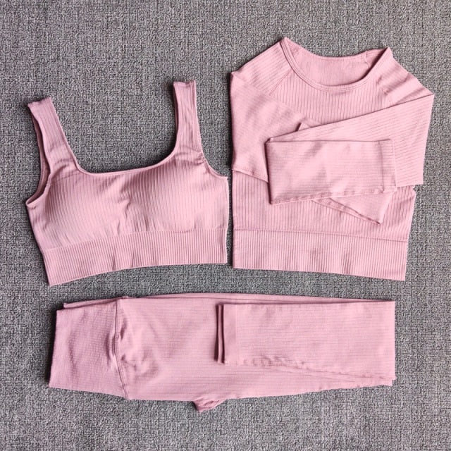 A stylish seamless yoga set for women, featuring leggings, a fitness bra, and a crop top in various colors including pink and black.