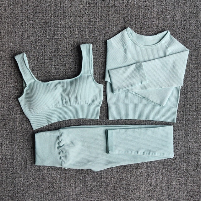 A stylish seamless yoga set for women, featuring leggings, a fitness bra, and a crop top in various colors including pink and black.