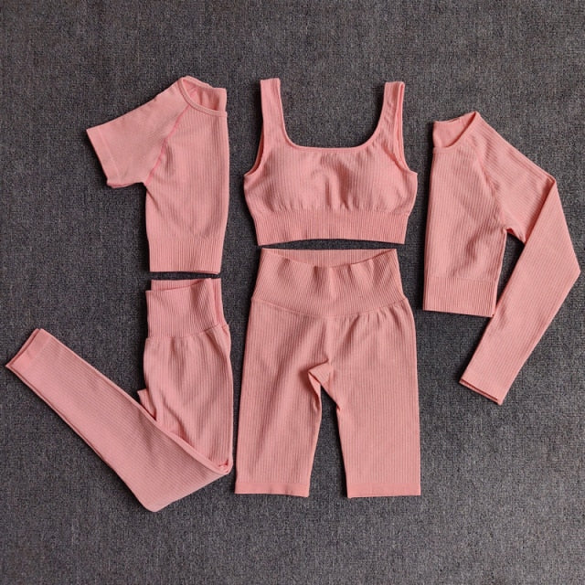 A stylish seamless yoga set for women, featuring leggings, a fitness bra, and a crop top in various colors including pink and black.