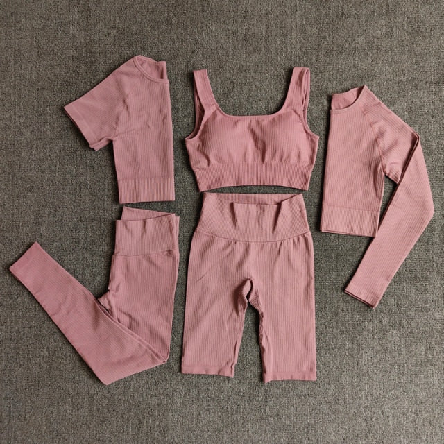 A stylish seamless yoga set for women, featuring leggings, a fitness bra, and a crop top in various colors including pink and black.