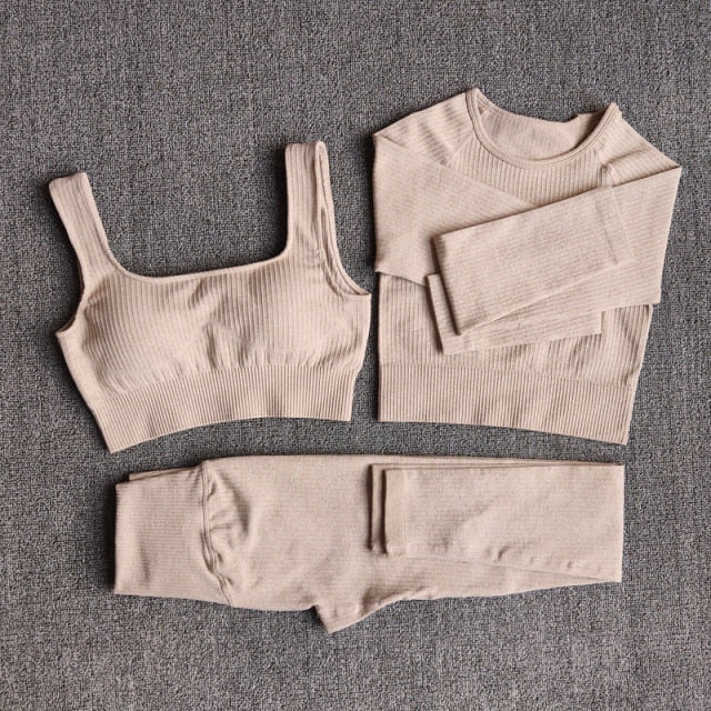 A stylish seamless yoga set for women, featuring leggings, a fitness bra, and a crop top in various colors including pink and black.