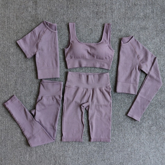 A stylish seamless yoga set for women, featuring leggings, a fitness bra, and a crop top in various colors including pink and black.