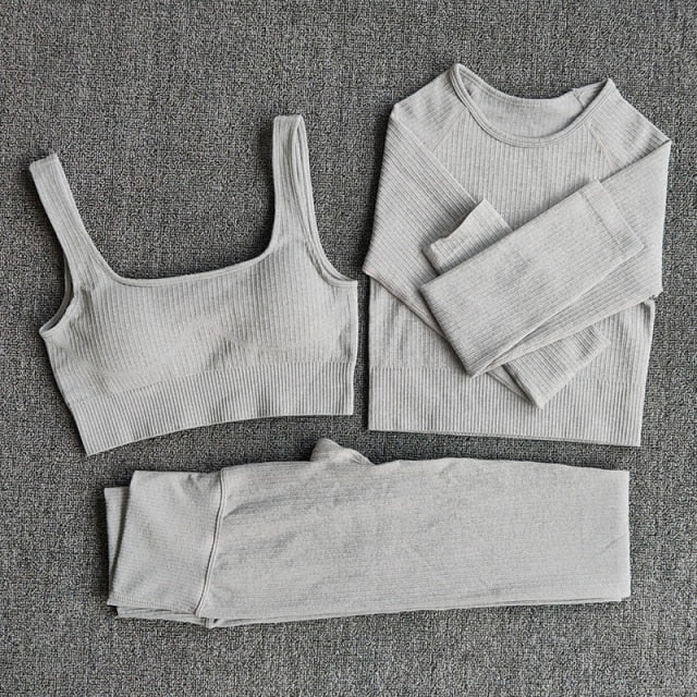 A stylish seamless yoga set for women, featuring leggings, a fitness bra, and a crop top in various colors including pink and black.