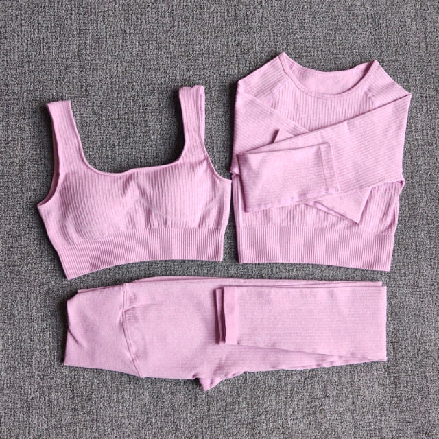 A stylish seamless yoga set for women, featuring leggings, a fitness bra, and a crop top in various colors including pink and black.