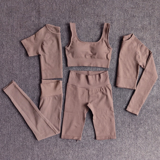 A stylish seamless yoga set for women, featuring leggings, a fitness bra, and a crop top in various colors including pink and black.