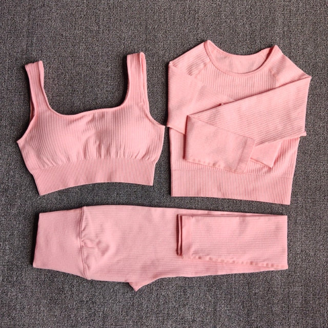 A stylish seamless yoga set for women, featuring leggings, a fitness bra, and a crop top in various colors including pink and black.